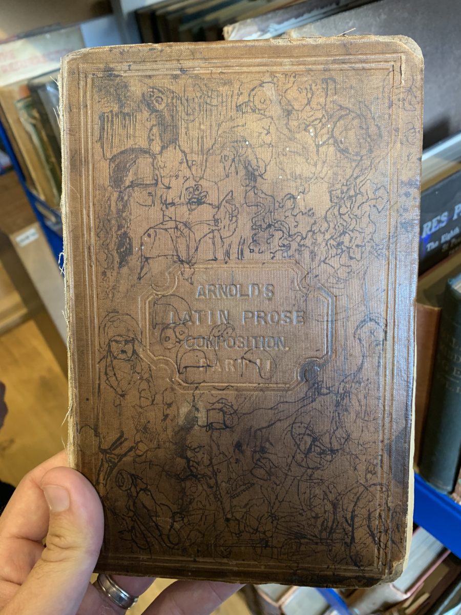 This book, "Arnold's Latin Prose Composition," was Chesterton's boyhood Latin book, and it's probably the most marked-up book in the library. Just look at the cover!